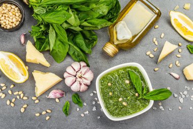Çam fıstığı, parmesan ve sarımsaklı bir kasede pesto sosu. Geleneksel İtalyan yemekleri, gri taş beton zemin, pankart biçimi, üst görünüm