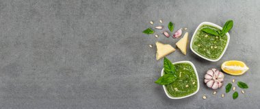 Çam fıstığı, parmesan ve sarımsaklı bir kasede pesto sosu. Geleneksel İtalyan yemekleri, gri taş beton zemin, pankart biçimi, pankart biçimi