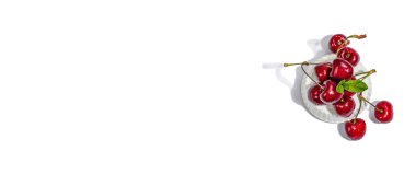 Beyaz arka planda izole edilmiş taze nane yapraklı olgun kirazlar. Modaya uygun beton standı, geleneksel yaz meyveleri, düz yatak, model, şablon, sert ışık, koyu gölge, bayrak