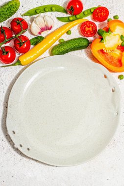 Vejetaryen sofrası. Olgun taze sebzeler, boş tabaklar, çatal bıçak takımı, baharatlar. Sert bir ışık, koyu gölge, aydınlık macun arkaplan, üst görünüm