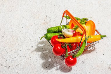Satış konsepti. Sepette farklı sebzeler. Yaz hasadı, modern aydınlık, karanlık gölge. Sağlıklı beslenme, hafif macun arkaplanı, kopyalama alanı