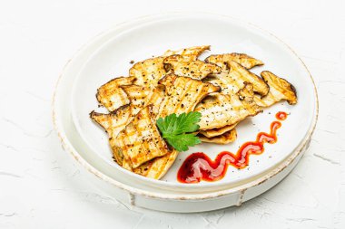 Fried slices Pleurotus eryngii mushrooms with sauce, spices and herbs. Healthy vegan food concept, white plaster background, flat lay, copy space