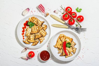 Fried slices Pleurotus eryngii mushrooms with sauce, spices and herbs. Healthy vegan food concept, hard light, dark shadowwhite plaster background, flat lay, top view