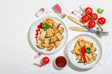 Fried slices Pleurotus eryngii mushrooms with sauce, spices and herbs. Healthy vegan food concept, hard light, dark shadowwhite plaster background, flat lay, top view