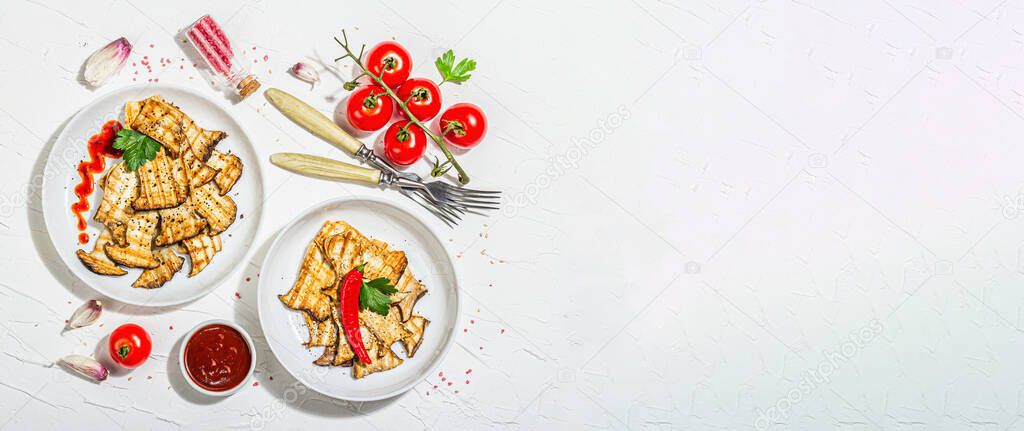 Fried slices Pleurotus eryngii mushrooms with sauce, spices and herbs. Healthy vegan food concept, hard light, dark shadowwhite plaster background, flat lay, banner format