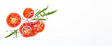 Assorted fresh vegetables and spices isolated on white background. Ripe tomato slices, purple onion, arugula and black peppercorn. Traditional ingredients for cooking healthy food, banner format