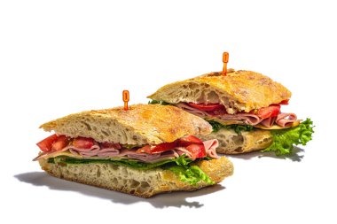 Panini sandwich with ham, crispy salad and vegetables isolated on white background. Healthy food to go concept, lunch or snack option. Trendy hard light, dark shadow
