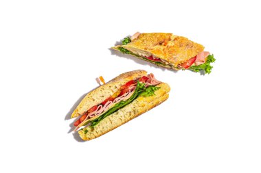 Panini sandwich with ham, crispy salad and vegetables isolated on white background. Healthy food to go concept, lunch or snack option. Trendy hard light, dark shadow
