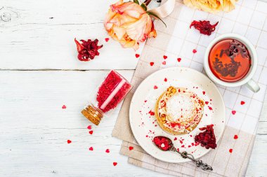 Romantik çay kavramı. Fransız Shu keki, amber çayı, bir buket gül, şenlikli dekor. Sevgililer Günü konsepti, Kadınlar Günü 8 Mart, Düğün. Beyaz tahta arka planı