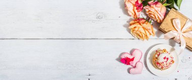 Romantik hediye kavramı. Fransız Shu keki, amber çayı, bir buket gül, şenlikli dekor. Sevgililer Günü konsepti, Kadınlar Günü 8 Mart, Düğün. Beyaz pano arkaplanı, pankart biçimi