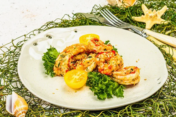 Grilled shrimp salad with lettuce, tomato cherries and spices on a plate. Fresh and healthy seafood, nautical decor. Trendy hard light, dark shadow, plaster background, close up