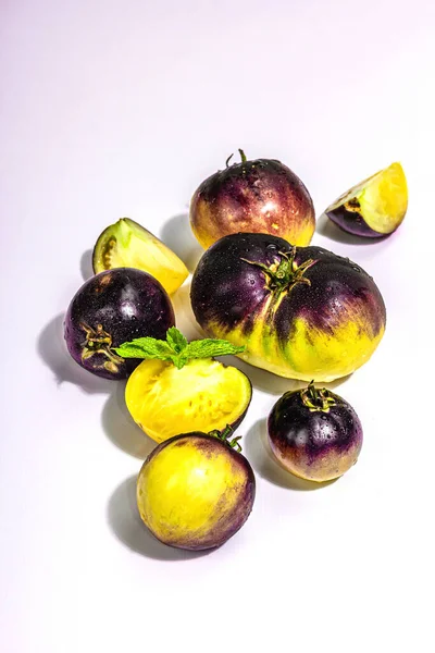 黄紫色のトマトの品種白い背景に孤立した一次色 熟した野菜の収穫 流行のハードライト 暗い影 — ストック写真