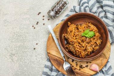 Lahana yahnisi yenmeye hazır. Ev yapımı vejetaryen yemeği. Baharatlar, otlar, taş beton arka planda çatal bıçak takımı, kırsal stil, üst manzara.