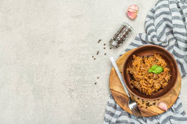 Lahana yahnisi yenmeye hazır. Ev yapımı vejetaryen yemeği. Baharatlar, otlar, taş beton arka planda çatal bıçak takımı, kırsal stil, üst manzara.