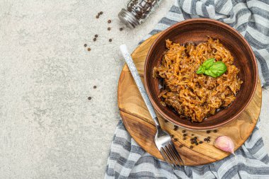 Lahana yahnisi yenmeye hazır. Ev yapımı vejetaryen yemeği. Baharatlar, otlar, taş beton arka planda çatal bıçak takımı, kırsal stil, üst manzara.