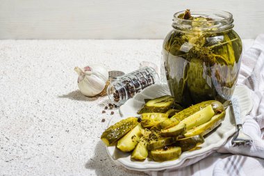 Kış organik gıdalar için salatalık turşusu. Bir kavanoz ev yapımı turşu, temiz yemek, vejetaryen konsepti. Modaya uygun sert ışık, koyu gölge, beyaz alçı arka plan