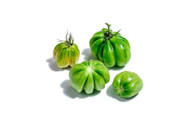 Beyaz arka planda izole edilmiş yeşil kabuklu domatesler. Amerikan ya da Floransalı çeşitleri. Modaya uygun sert bir ışık, karanlık bir gölge, model, şablon, düz uzanma