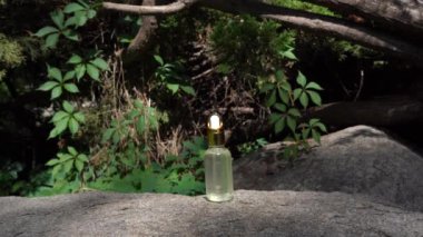 Serum cam şişede, arka planda gölgeli. Aromaterapi yağı, doğal kozmetik kavramı.