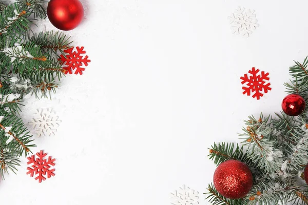 Kırmızı süslemeli ve beyaz arka planda kar taneleri olan bir Noel kartı. Mutlu yıllar teması