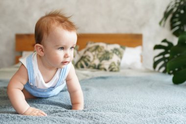 Evde, aydınlık odada, yatakta oynayan tatlı bir bebek.