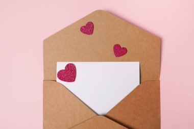 Sevgililer Günü için bir tebrik kartı hazırla. Pembe arka planda sevgililer günü için kırmızı kalpli kompozisyon. Düz yatıyordu