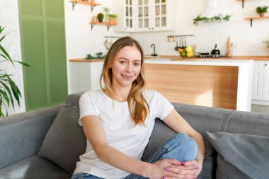 evde koltukta oturan genç çekici kadın