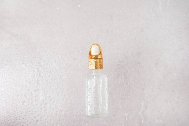 Su damlalı kozmetik yağı şişesi, gerekli cilt bakımı yağı.