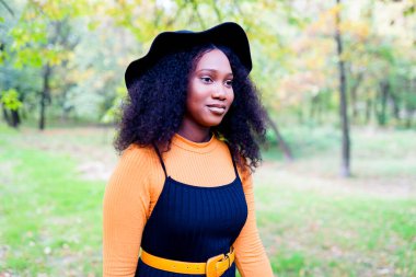 Çekici kıvırcık saçlı, esmer, dişlek bir kadının portresi.