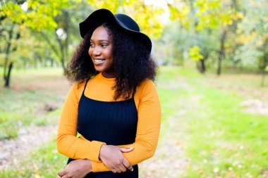 Çekici kıvırcık saçlı, esmer, dişlek bir kadının portresi.