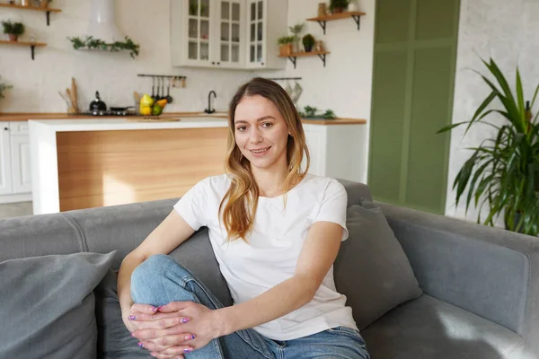 Genç bir kadın uzun bir günün ardından kanepede dinleniyor. Konforlu ev kavramı