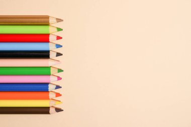 Açık arkaplan üzerinde tahta renkli kalemler kopyalama alanı ile