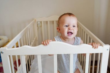 Küçük bebek yatakta gülümsüyor.