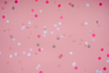 Pembe arka planda renkli parti konfetileri. Üst manzara, düz uzanma