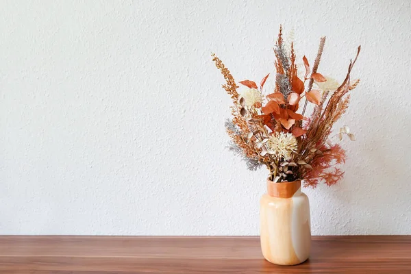 Composition of dried flowers in ceramic vase as home decoration. autumn bouquet, white wall with copy space