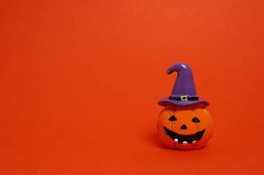 Cadılar Bayramı balkabağı jack o fener dekor kırmızı arka planda komik bir yüz, kopyalama alanı