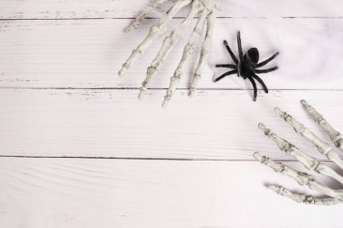 İskelet elli ve örümcek ağlı cadılar bayramı beyaz ahşap arka planı, kopyalama alanı, düz yatış. Cadılar Bayramı, şeker ve hile