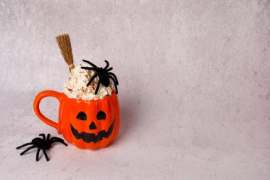 Gri arka planda örümcekler olan turuncu kahve fincanı, kopyalama alanı.