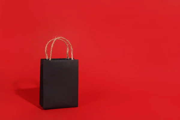 Bolsa Compras Papel Negro Con Sombra Sobre Fondo Rojo Espacio — Foto de Stock