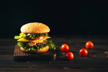 Homemade beef burgers and french fries on dark background.