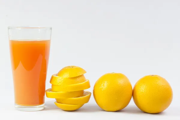 Orangensaft und Orangenscheiben auf Weiß — Stockfoto