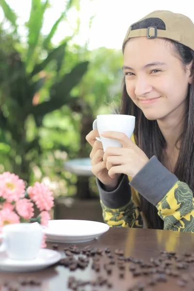 Kvinna med kopp kaffe leende i café — Stockfoto
