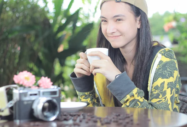 Mujer sosteniendo taza de café sonriendo en la cafetería — Foto de Stock