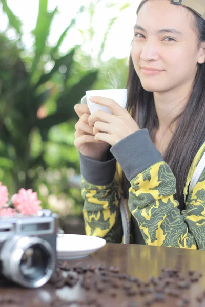 Mulher segurando xícara de café sorrindo no café — Fotografia de Stock