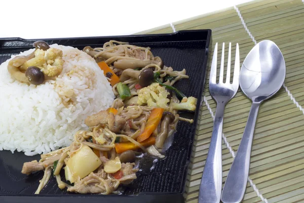 Faire revenir les champignons avec du riz sur une assiette noire Photos De Stock Libres De Droits