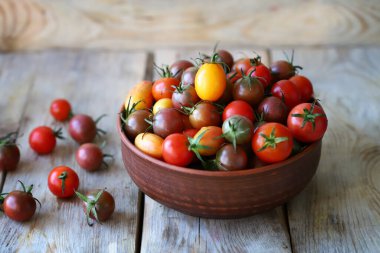 Kasede ve tahta yüzeyde mini domatesler. Domates hasat et..