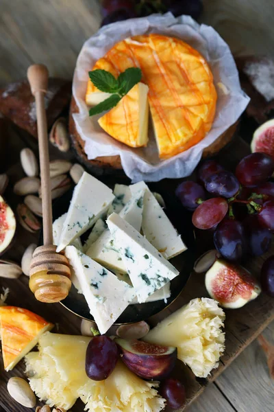 Seçici odaklanma. Cevizli, meyveli ve ballı peynir tahtası..