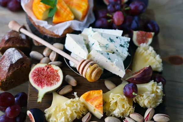 Seçici odaklanma. Cevizli, meyveli ve ballı peynir tahtası..