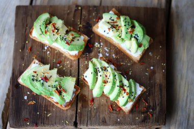 Seçici odaklanma. Tahtada avokado olan lezzetli bir tost..