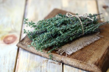 Seçici odaklanma. Tahta yüzeyde bir demet taze kekik..