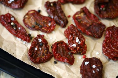 Seçici odaklanma. Makro. Fırın tepsisinde güneşte kurutulmuş domatesler. Güneşte kurutulmuş domates yapıyorlar..